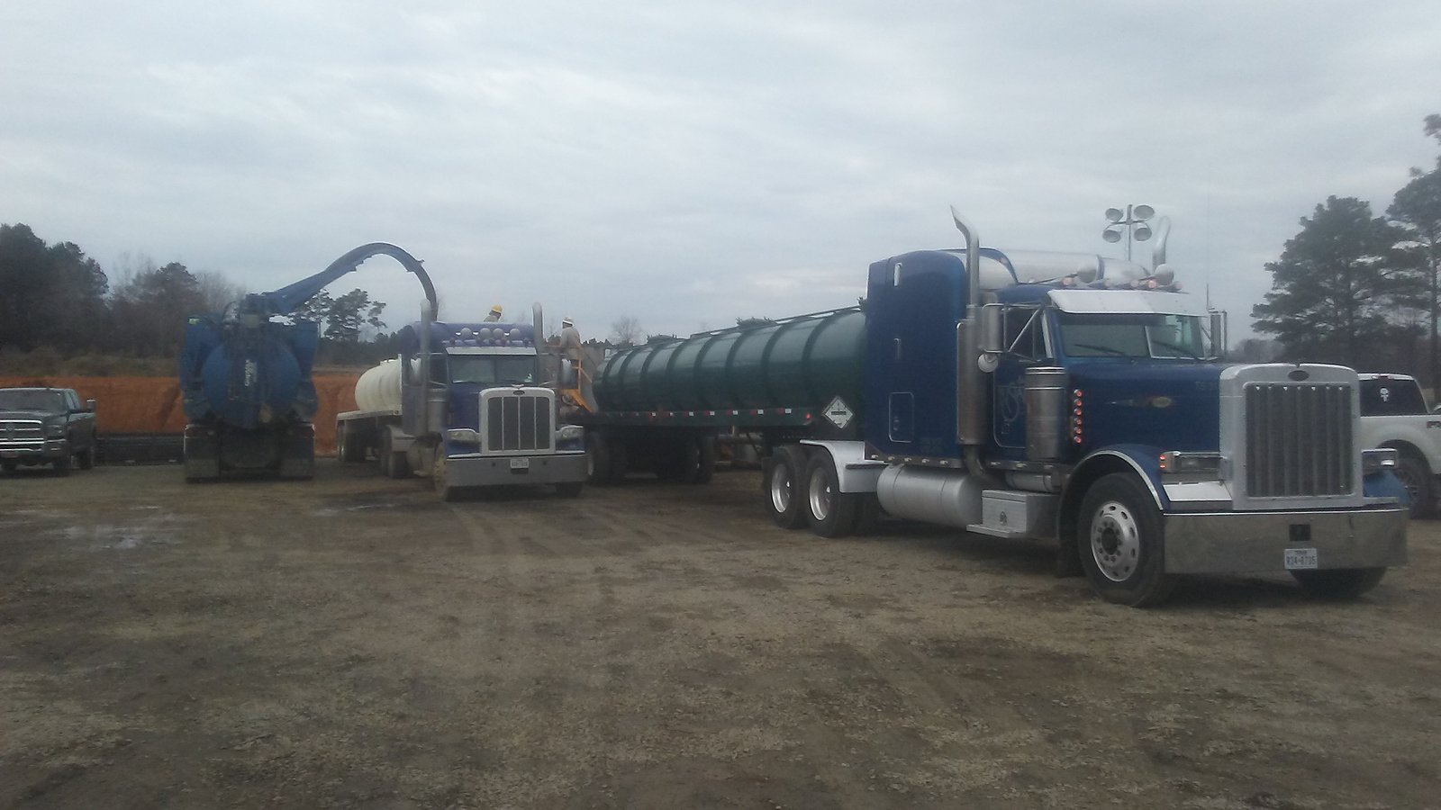 Blue trucks and vacuum on a muddy location