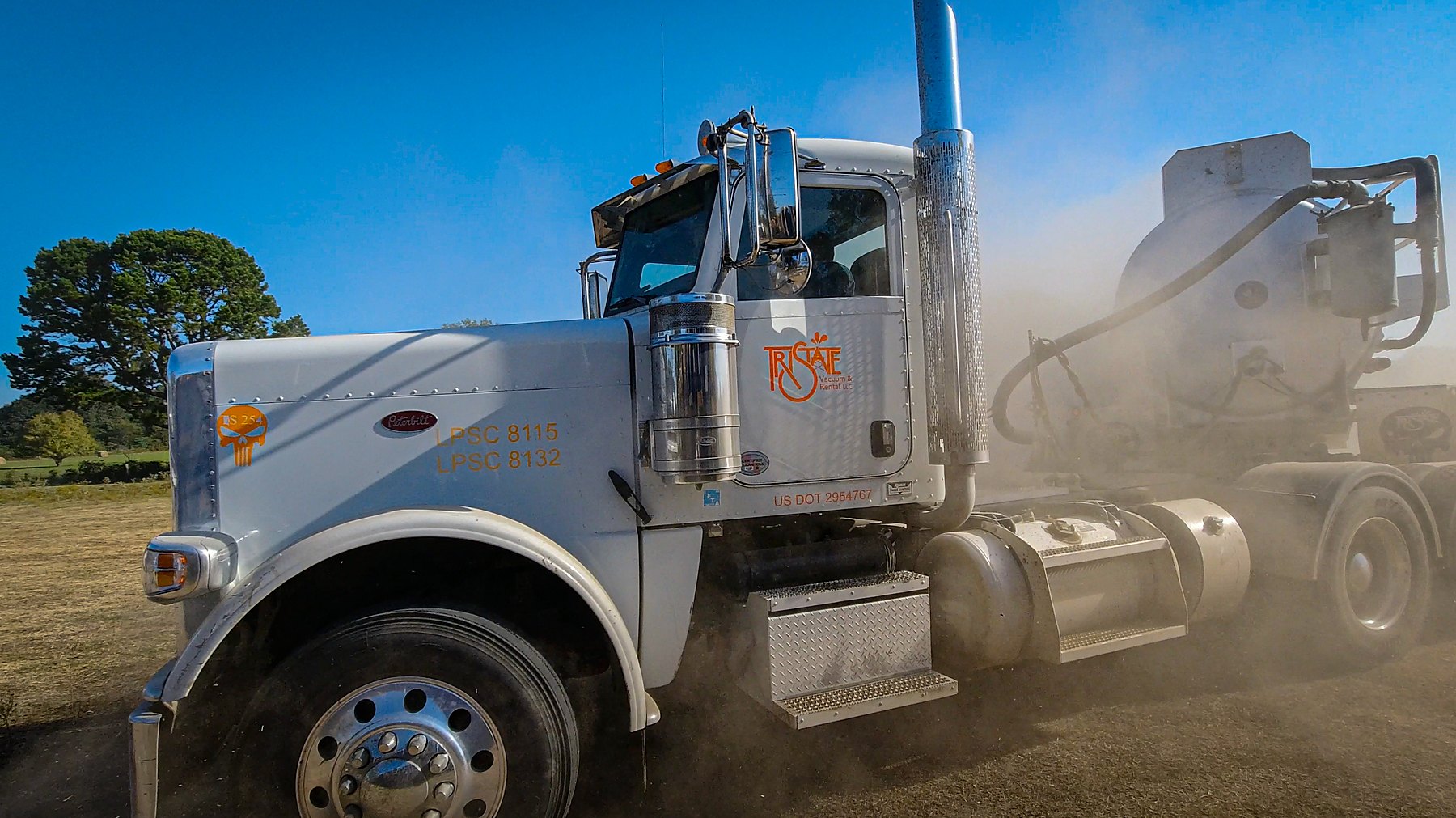 White vacuum truck in the field